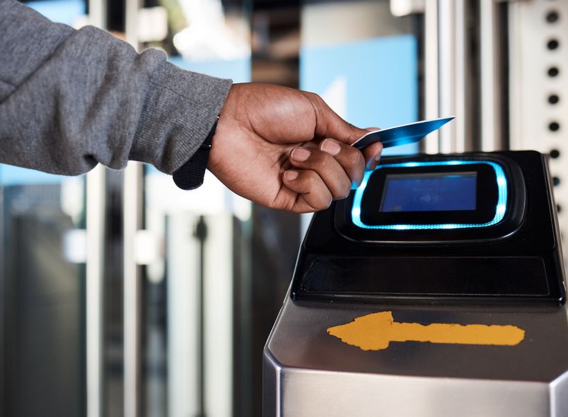 A person tapping a contactless card onto a machine